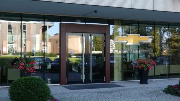 Fachada de cristal de un moderno edificio de oficinas con logo Chevrolet. Representación Editorial 3D — Vídeo de stock