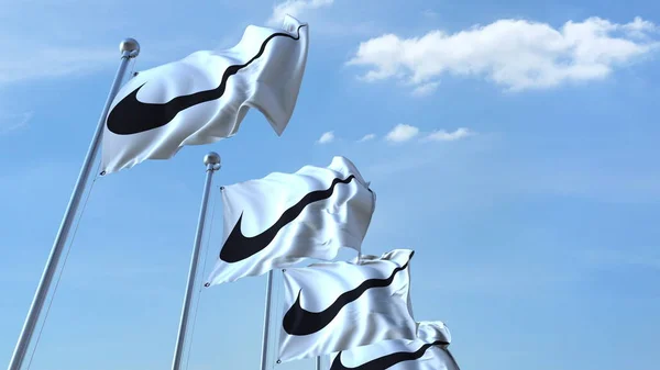 Ondeando banderas con el logotipo de Nike contra el cielo, representación editorial 3D — Foto de Stock