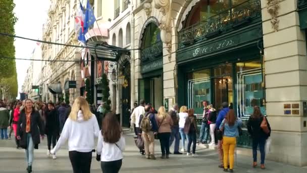 PARIS, FRANCIA - 7 DE OCTUBRE DE 2017. Camine por la abarrotada acera y escaparates de la calle Champs-Elysees — Vídeo de stock