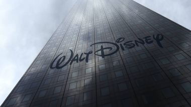 Walt Disney Pictures logo on a skyscraper facade reflecting clouds. Editorial 3D rendering clipart