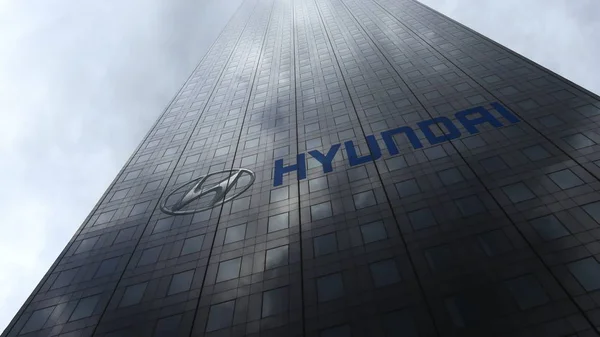 Логотип Hyundai Motor Company на фасаде небоскреба, отражающем облака. Редакционная 3D рендеринг — стоковое фото