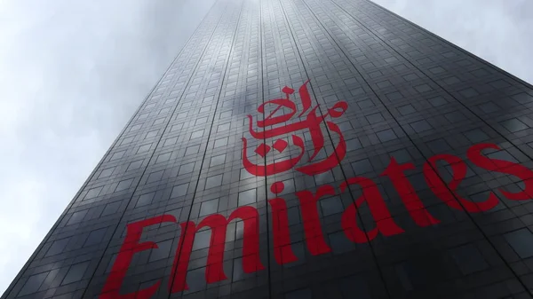 Emirates Airline logo op een gevel van de wolkenkrabber weerspiegeling van wolken. Redactioneel 3D-rendering — Stockfoto