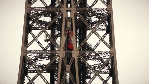 Красный лифт поднимается на вершину Эйфелевой башни в Париже. Телефото-объектив — стоковое видео