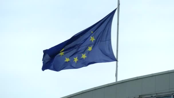 Kopott az Európai Unió zászlaját lengetve a tetőre, az épület — Stock videók