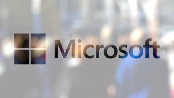 A Microsoft embléma egy üveg szemben a steet homályos tömeg. Szerkesztői 3d-leképezés — Stock videók