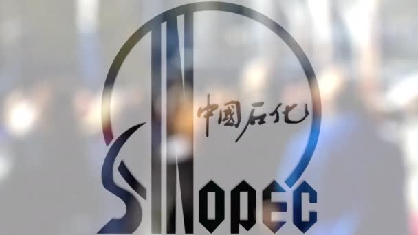 Логотип Sinopec на стакане против размытой толпы на стите. Редакционная 3D рендеринг — стоковое видео