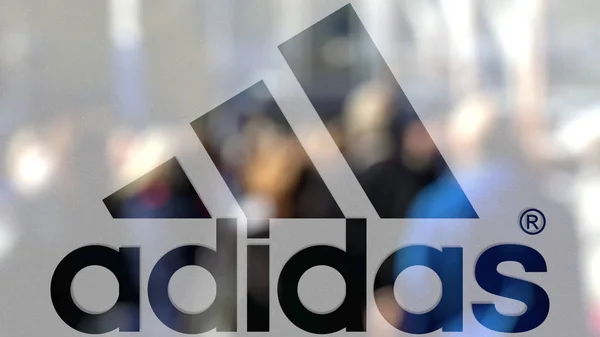 Adidas επιγραφή και λογότυπο σε ένα ποτήρι κατά θολή πλήθος της οδού. Συντακτική 3d rendering — Φωτογραφία Αρχείου