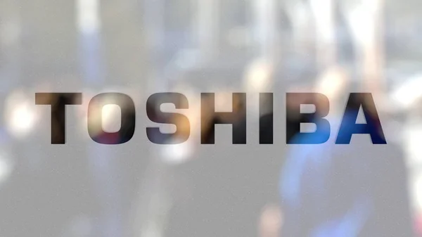 Toshiba corporation logo auf einem Glas vor verschwommener Menschenmenge auf dem Steet. redaktionelles 3D-Rendering — Stockfoto