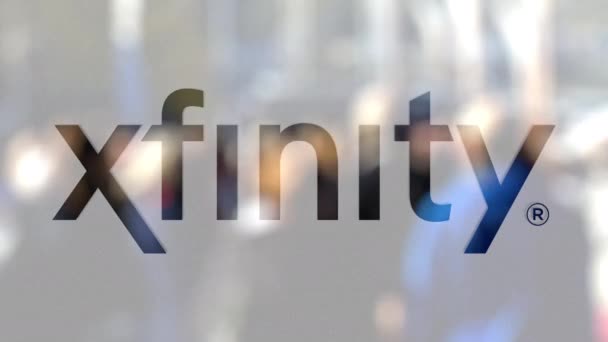Xfinity λογότυπο σε ένα ποτήρι κατά θολή πλήθος της οδού. Συντακτική 3d rendering — Αρχείο Βίντεο