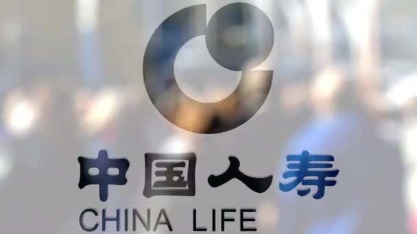Логотип Китайской страховой компании на стакане против размытой толпы на стите. Редакционная 3D рендеринг — стоковое видео