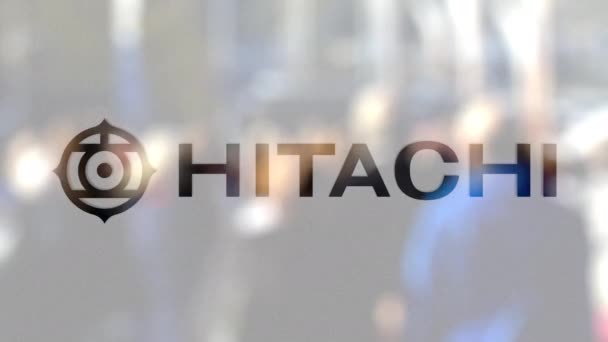 Hitachi logo na szklance przed niewyraźne tłum na ulicę. Redakcji renderowania 3d — Wideo stockowe