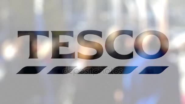 Tesco logo na sklenici proti rozmazané dav na steet. Úvodník 3d vykreslování — Stock video