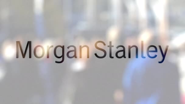 Логотип Morgan Stanley Inc. на стакане против размытой толпы на стите. Редакционная 3D рендеринг — стоковое видео