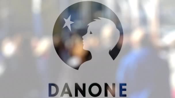 Danone logo på ett glas mot suddig publiken på steet. Redaktionella 3d-rendering — Stockvideo