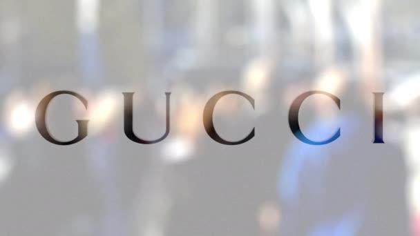 Logo Gucci su un bicchiere contro la folla sfocata sul manzo. Rendering editoriale 3D — Video Stock