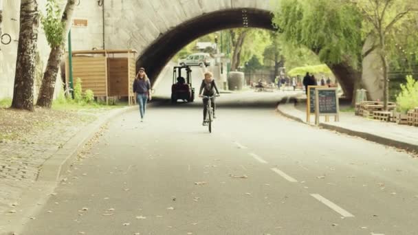 PARÍS, FRANCIA 8 DE OCTUBRE DE 2017. Mujer en bicicleta por la calle cafetería a lo largo del terraplén del río Sena — Vídeo de stock