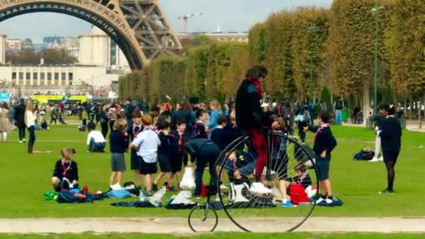 PARIS, FRANCE - OCTOBER 7, 2017. Man riding big wheel retro bicycle on Champ de Mars near the Eiffel tower — Stock Video