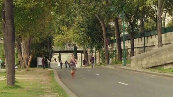 PARÍS, FRANCIA 8 DE OCTUBRE DE 2017. Corredor femenina corriendo a lo largo del terraplén del río Sena en un día de otoño — Vídeo de stock