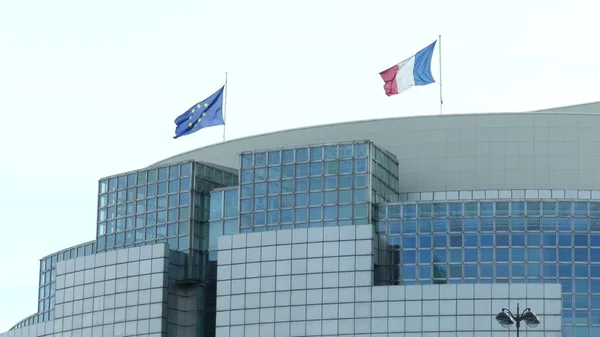 Banderas ondeando de Francia y de la Unión Europea en el tejado de un edificio moderno en París — Foto de Stock