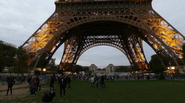 Paris, Frankrike - 7 oktober 2017. Turister gör bilder nära belysta Eiffeltornet kvällstid — Stockfoto