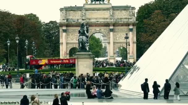 PARIS, FRANCE - OCTOBER 8, 2017. Crowded square near the Louvre Museum pyramids and Arc de Triomphe du Carrousel, a triumphal arch — Stock Video