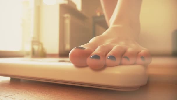 Vrouw stond op de schaal van het gewicht in een zonnige kamer — Stockvideo