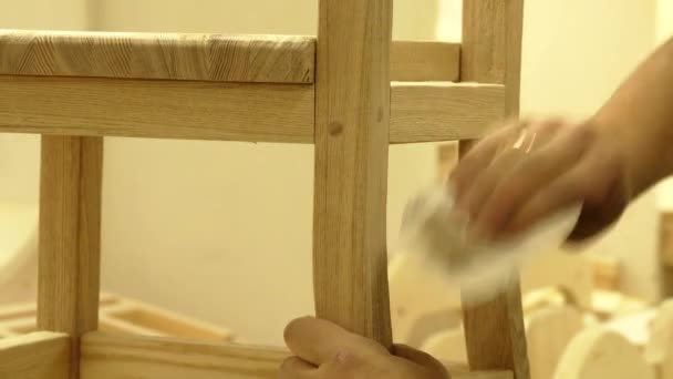 Profi-Schreiner schleift Holzstuhl mit Schleifpapier, um die Oberfläche glatt zu machen — Stockvideo
