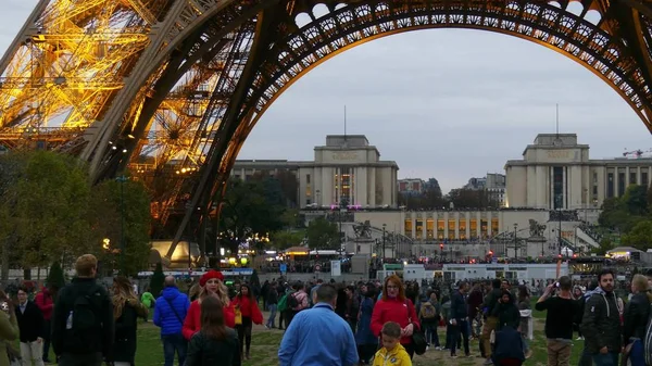 Paris, Frankrijk - 7 oktober 2017. Toeristen onder de Eiffeltoren in de avond — Stockfoto