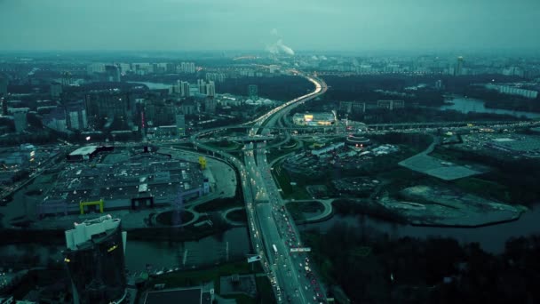 Foto aérea de la intersección de grandes autopistas de la ciudad. Enormes atascos de tráfico cerca de centros comerciales en la hora punta de la noche — Vídeo de stock