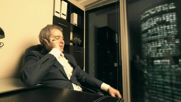 Businessman talking on his cell phone in the office in downtown in the evening — Stock Photo, Image