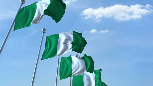 Meerdere wapperende vlaggen van Nigeria tegen de blauwe hemel. 3D-rendering — Stockfoto