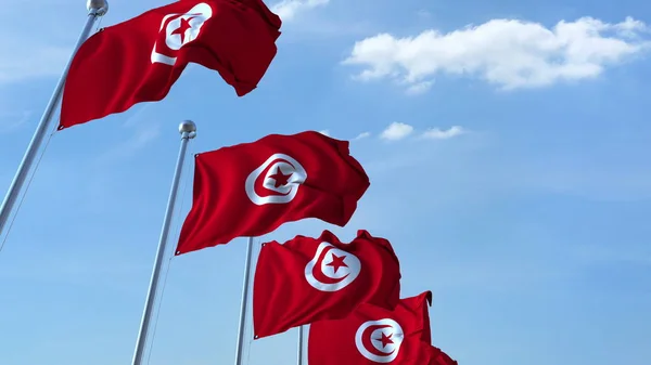 Více vlající vlajky Tuniska proti modré obloze. 3D vykreslování — Stock fotografie