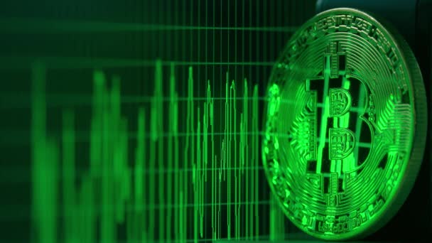 Glänsande bitcoin återspeglar gröna data graph på datorskärmen — Stockvideo