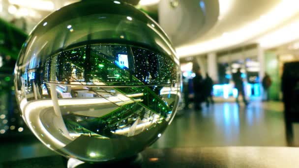 Centro comercial interior decorado para Navidad y Año Nuevo como se ve a través de la bola de vidrio — Vídeo de stock