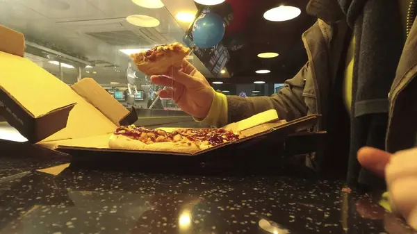 Moskva, Ryssland - 17 December 2018. Mannen äter nymalen bakad ångande pizza på Dominos — Stockfoto