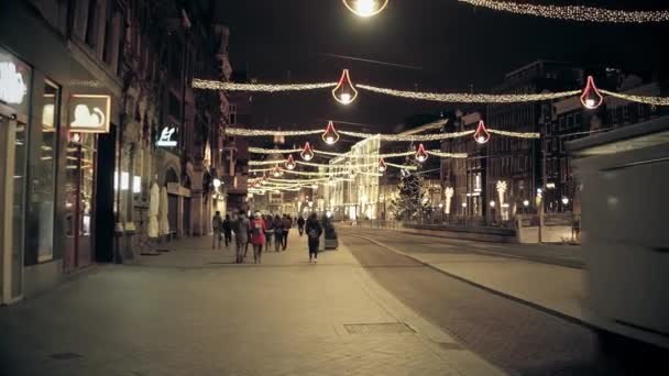 Amsterdam, Nizozemsko - 25 prosince 2017. Noční procházka podél hlavní ulice města POV ozdoben na Vánoce a nový rok — Stock video