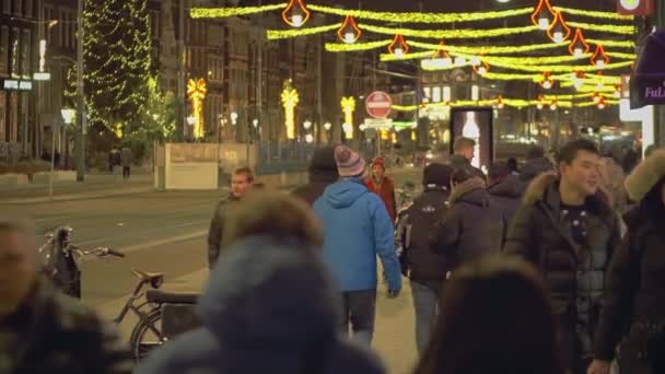 AMSTERDAM, PAÍSES BAJOS - 25 DE DICIEMBRE DE 2017. Crowded calle turística en el centro de la ciudad en la víspera de Navidad — Vídeos de Stock