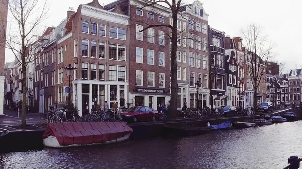 AMSTERDAM, PAÍSES BAJOS - 25 DE DICIEMBRE DE 2017. Típico terraplén del canal de la ciudad y las fachadas de casas holandesas —  Fotos de Stock