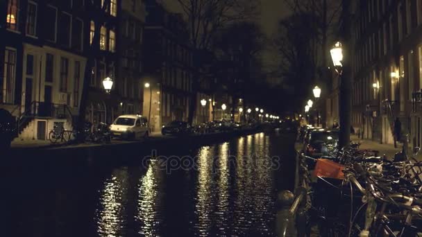 Canal and houses on embankments in Amsterdam at night — Stock Video