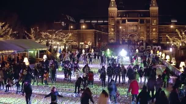Amsterdam, Nizozemsko - 28 prosinec 2017. Přeplněné kluziště poblíž slavné zaregistruji amsterdam na muzejní čtvrť nebo Museumplein v noci — Stock video