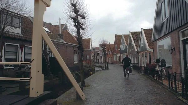 Mujer ciclista desconocida paseando por la calle en una pequeña ciudad holandesa, Países Bajos —  Fotos de Stock