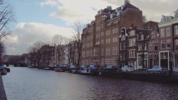 AMSTERDAM, THE NETHERLANDS - DECEMBER 25, 2017. City canal embankment and the Dutch houses facades — Stock Video