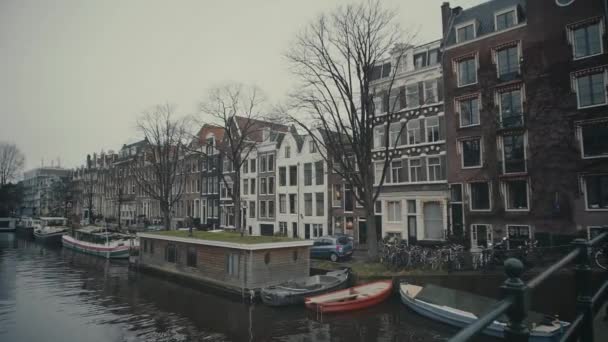 AMSTERDAM, NETHERLANDS - DECEMBER 26, 2017. City canal and moored boat houses — Stock Video