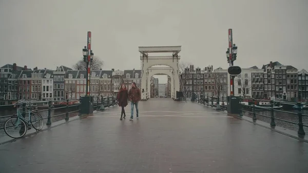 Амстердам, Нідерланди - 26 грудня 2017 року. Пара ходьба на знаменитий Magere Brug або "худий міст" — стокове фото