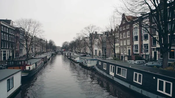 Typische hausboote entlang der stadtkanal-botschaften in amsterdam, niederland — Stockfoto