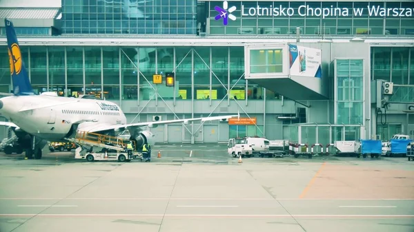 ADVERTÊNCIA, POLÓNIA - DEZEMBRO 25, 2017. Carregando bagagem para o avião comercial da Lufthansa no aeroporto internacional de Chopin — Fotografia de Stock