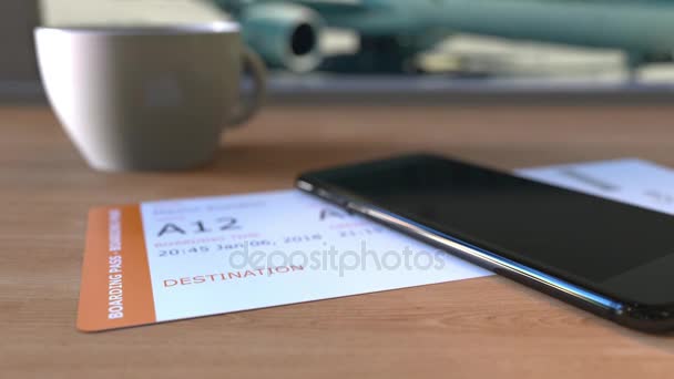 Boarding pass ke Helsinki dan smartphone di atas meja di bandara. Perjalanan ke Finlandia animasi konseptual — Stok Video