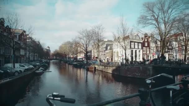 AMSTERDAM, NETHERLANDS - DECEMBER 26, 2017. Walk along the bridge over city canal — Stock Video