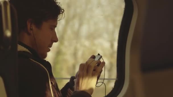 Amsterdam, Nizozemsko - 28 prosinec 2017. Mladý muž používá svůj smartphone ve vlaku — Stock video