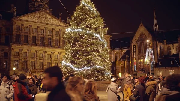 Amsterdam, Holandia - 28 grudnia 2017 r. Zatłoczone urządzony Plac Dam, Pałac Królewski i Kościół Nieuwe Kerk w godzinach wieczornych — Zdjęcie stockowe